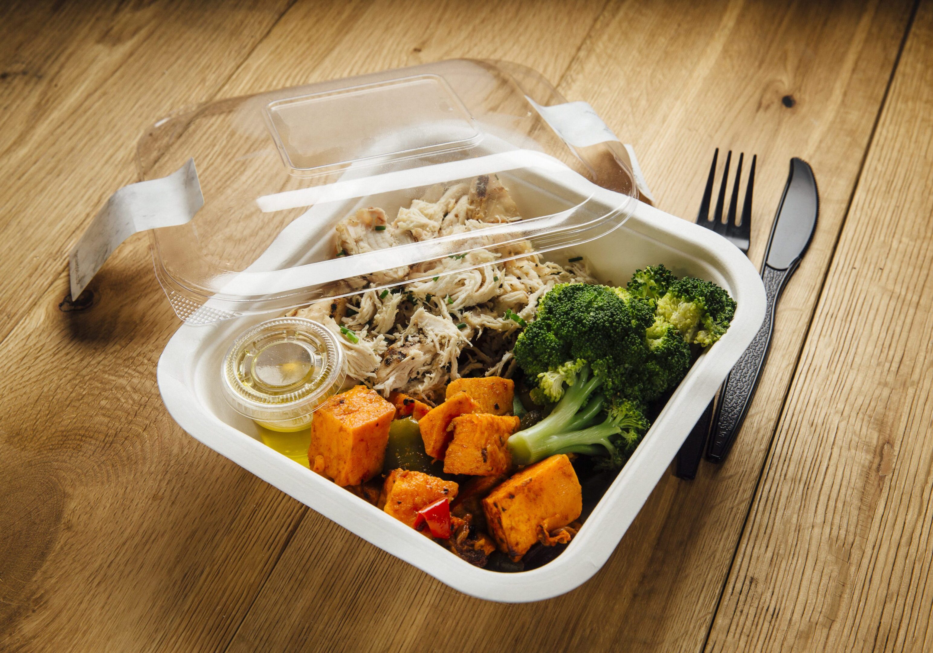 Ready-To-Eat chicken dinner meal with brocolli, sweet potato, peppers and an oil drizzle.